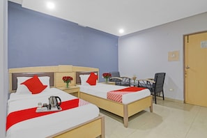 A hotel room with two beds, a desk, a chair, and a door. - Hotel O by OYO Padmini Near Lakdikapool (Hyderabad)
