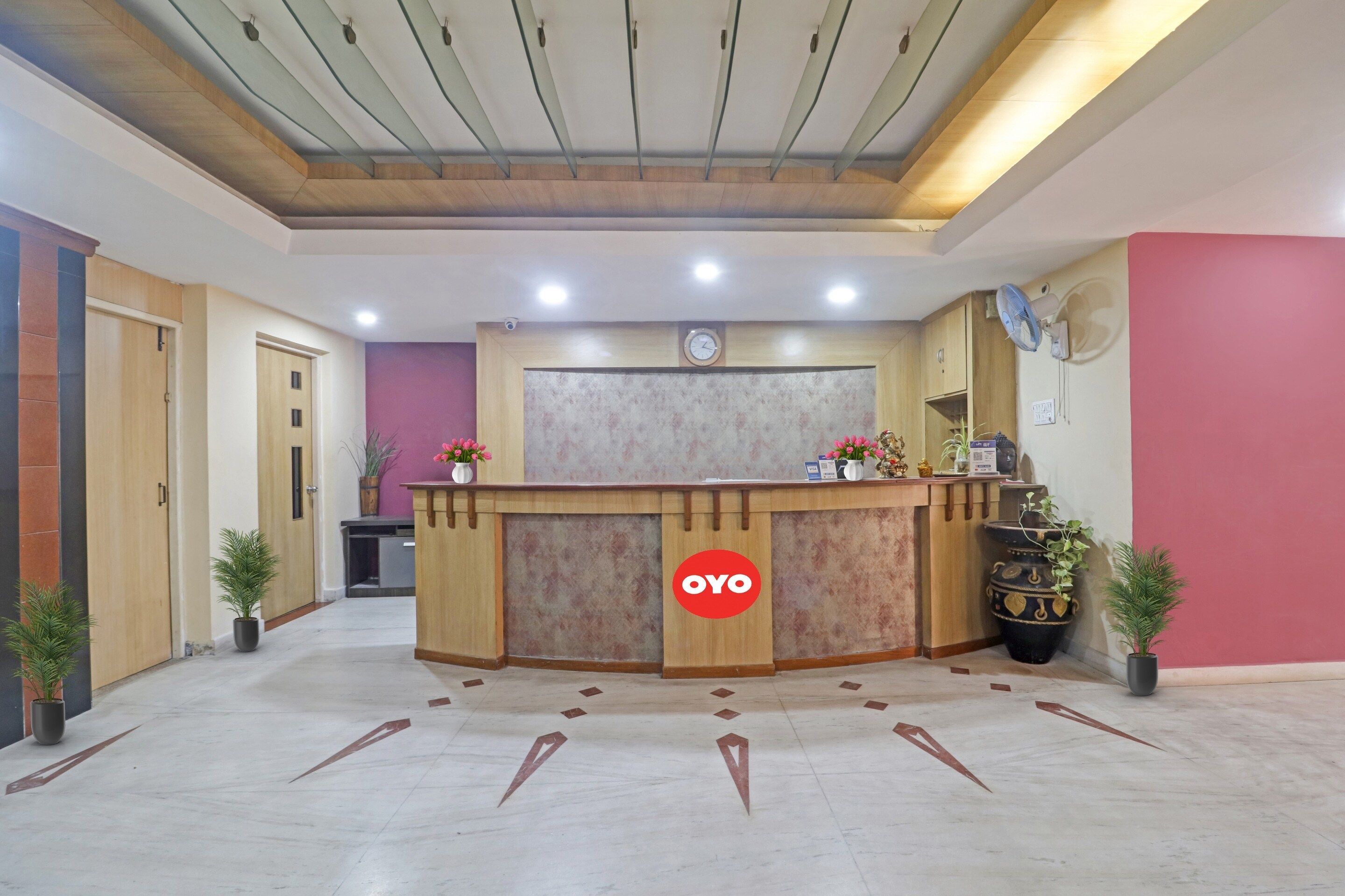 A reception area with a wooden reception desk, a clock, and a security camera.