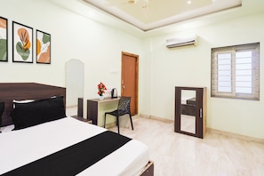 A hotel room with a bed, a desk, a chair, a window, and artwork on the wall. - Hotel O Charminar international Hotel (Hyderabad)
