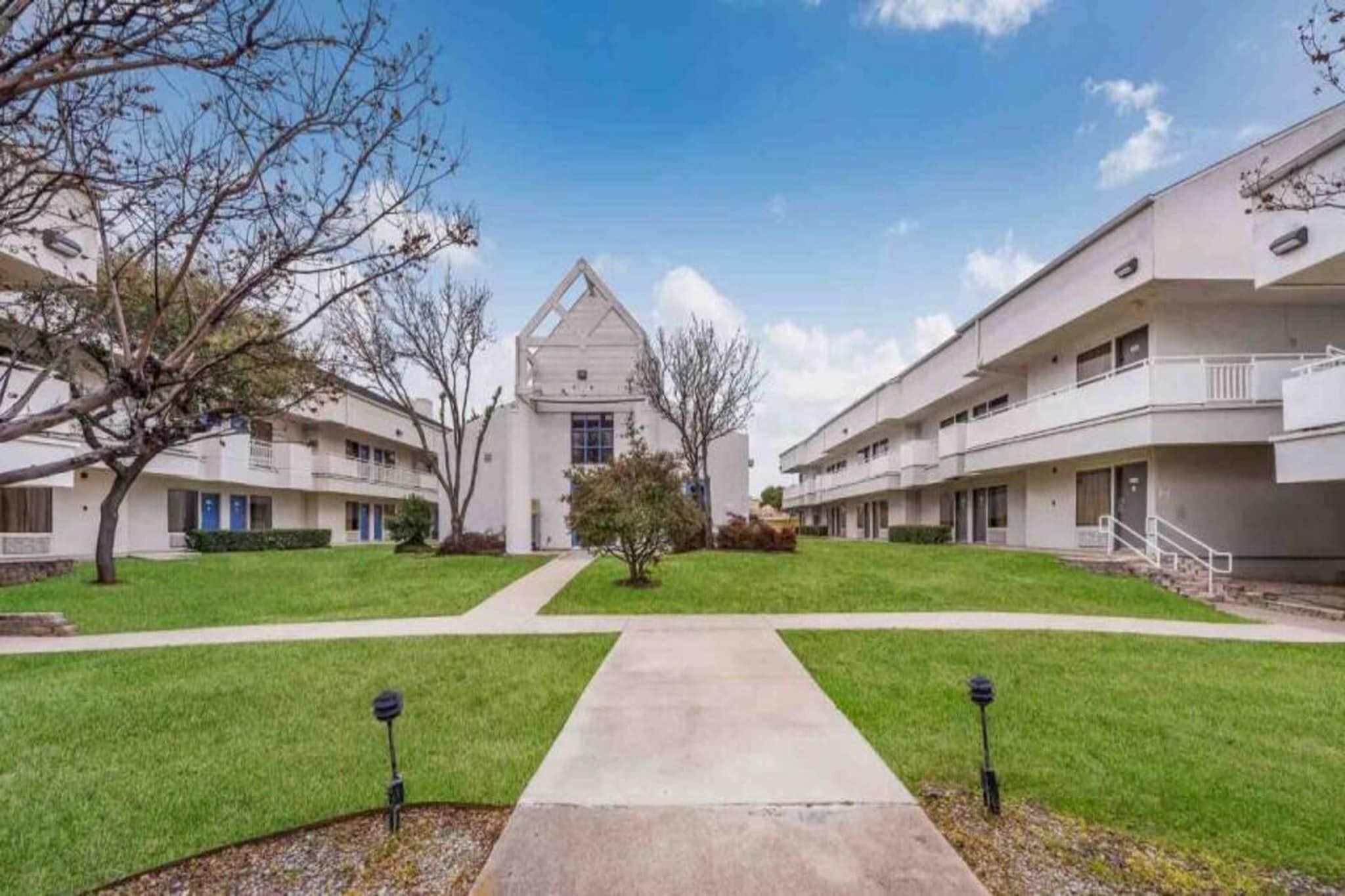 A residential building with a central courtyard, multiple balconies, and a symmetrical design.