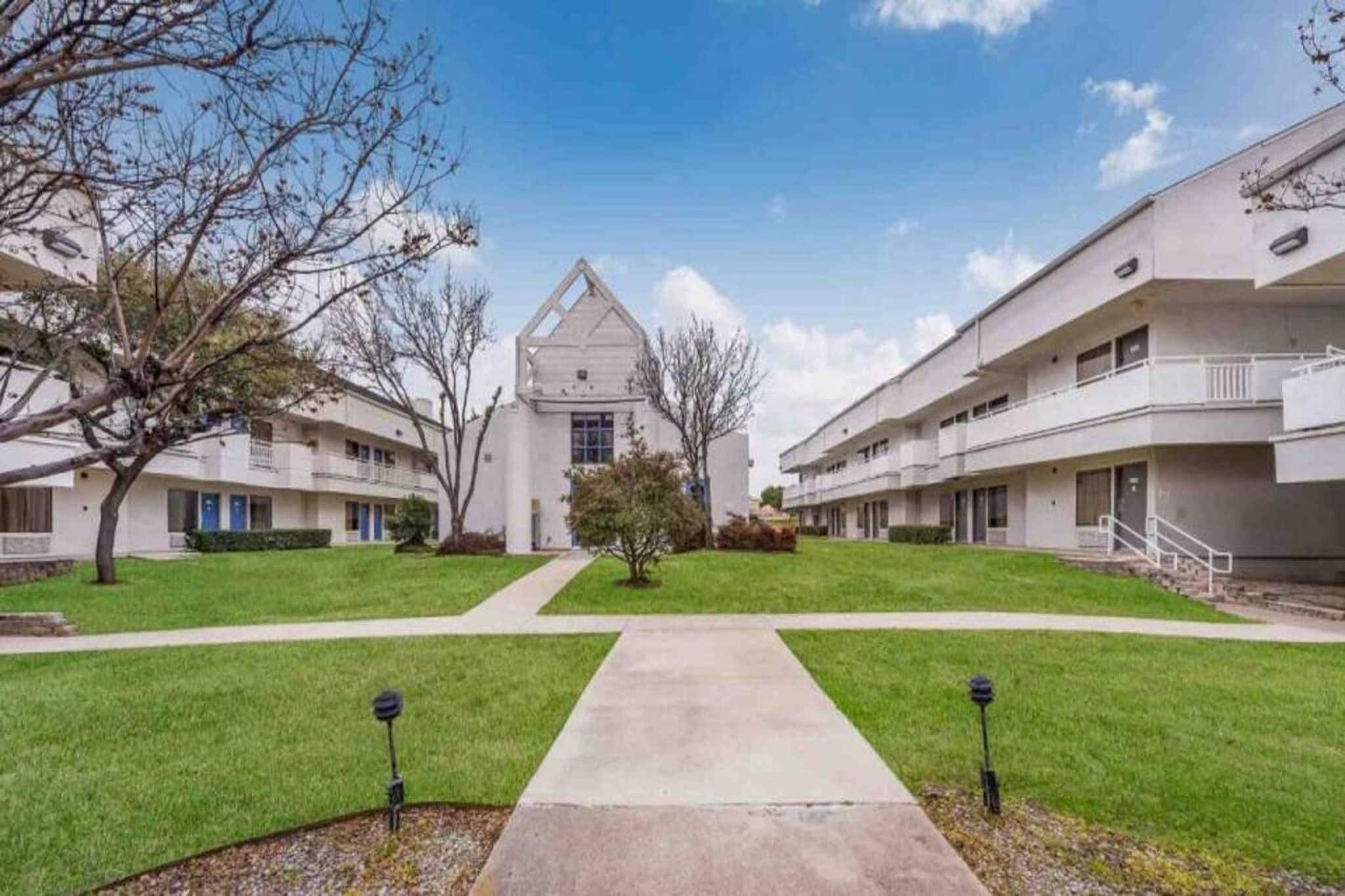 A residential building with a central courtyard, multiple balconies, and a symmetrical design.