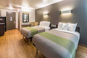 A hotel room with two beds, a small table, a mirror, and a door. - 2 Queen Beds|NS| Kitchen (New Braunfels)