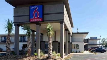 A hotel with a sign indicating 'studio 6 extended stay.'