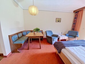 A room with a bed, a sofa, a table, and two chairs. - Vergissmeinnicht by Interhome (Sankt Ulrich am Pillersee)