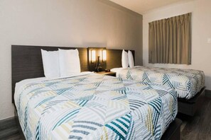 A hotel room with two beds, a nightstand, a lamp, and a window with curtains. - 2 Full Beds | Micfridge (Baytown)