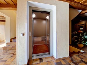 Een lift met een structuurwand, een handgreep en een bordje dat een privéterrein aangeeft.