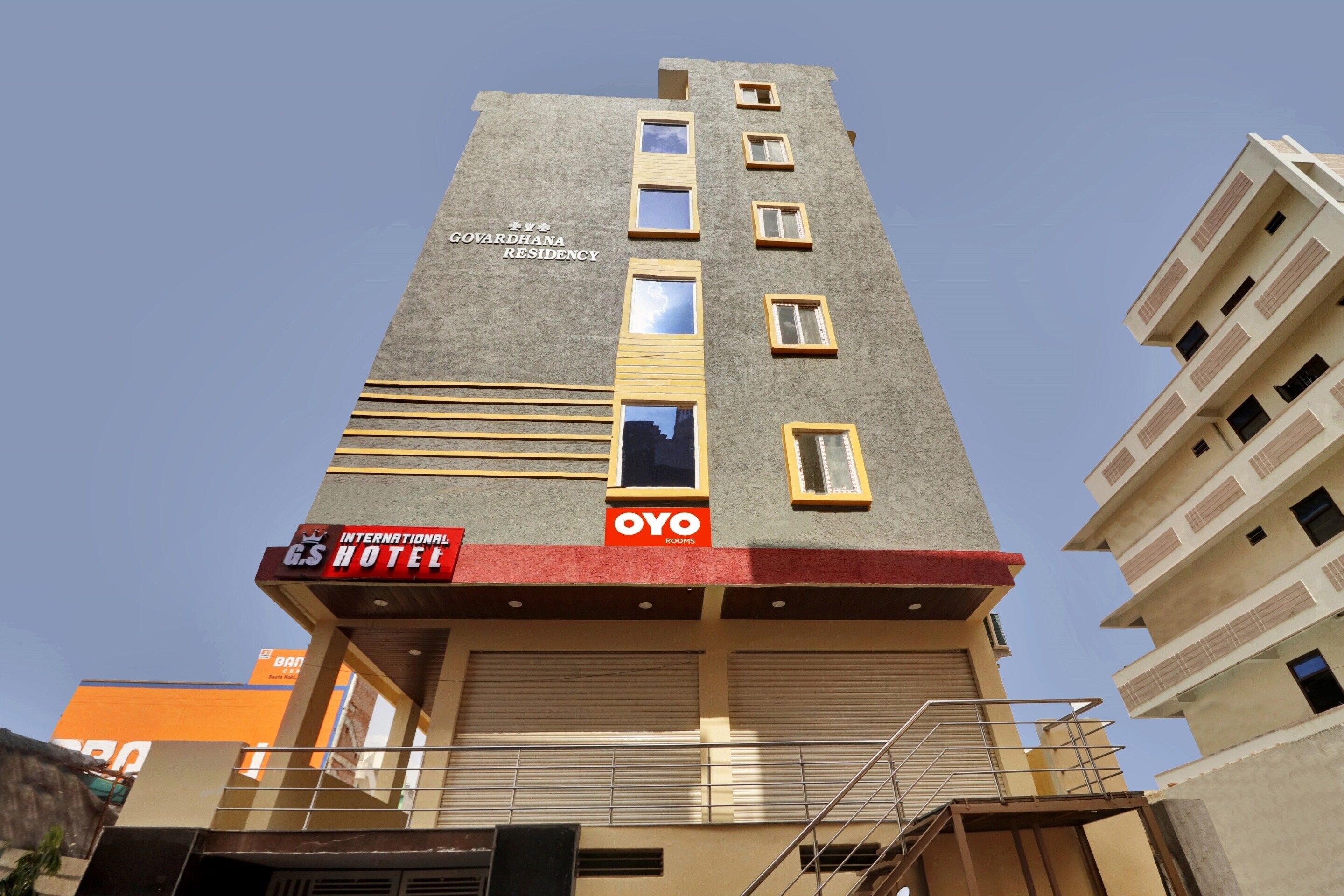 A multi-story hotel with a sign for 'G.S Hotel' and 'OYO Rooms' on the ground floor.