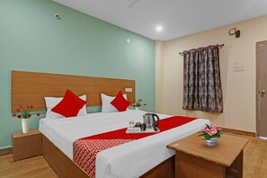 Quarto de hotel com cama, mesa de cabeceira, janela com cortinas e porta.