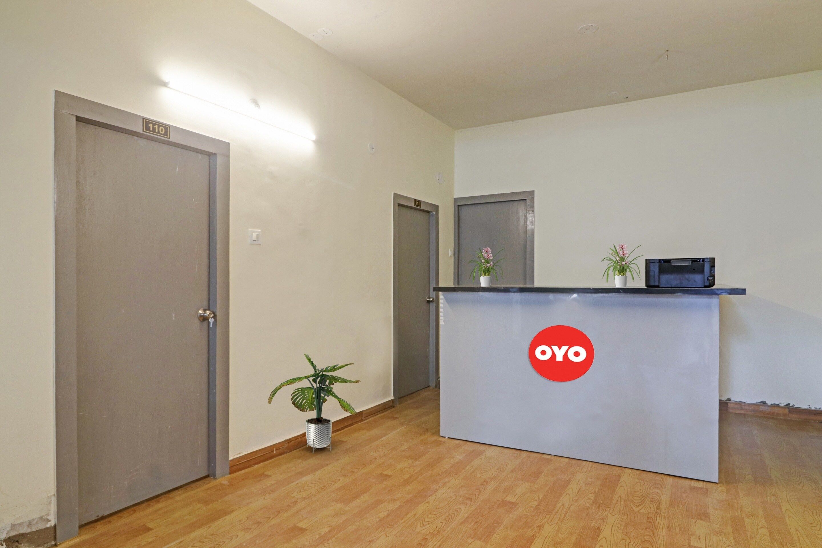 A reception area with a desk, a plant, and a sign that reads 'OYO'.