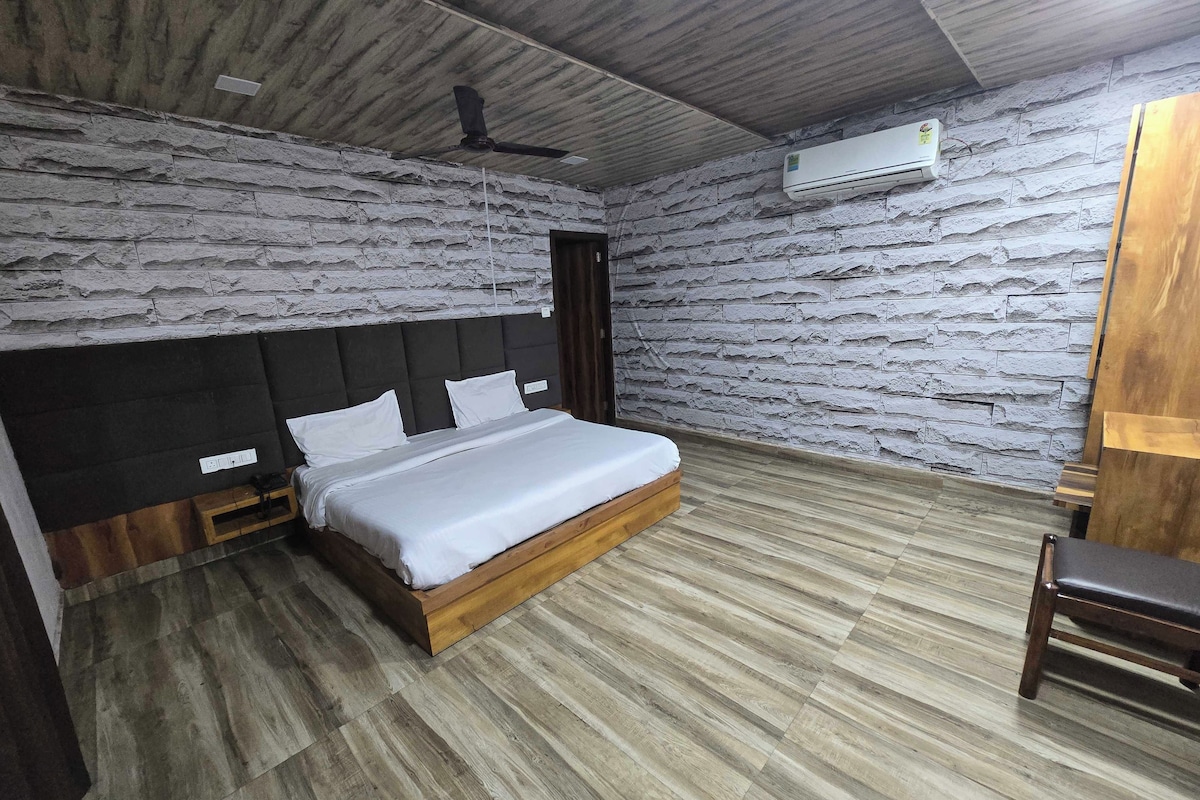 A bedroom with a bed, a wooden headboard, a ceiling fan, and an air conditioning unit.