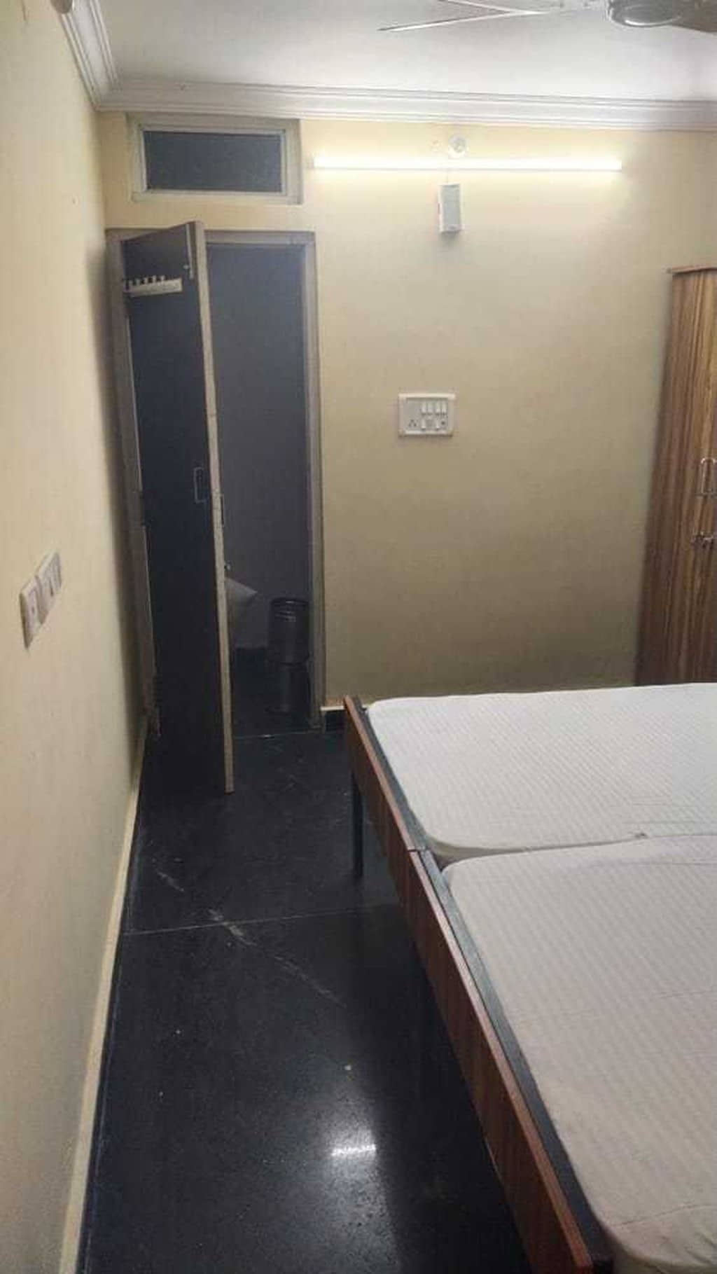 Una habitación pequeña con una cama, un armario y una puerta que da a otra habitación.