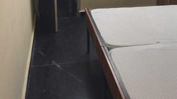 Una habitación pequeña con una cama, un armario y una puerta que da a otra habitación.