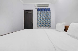 A single bed with white bedding, a dark door, and a window with a blue curtain. - Hotel O White Carnations Hotels (Hyderabad)