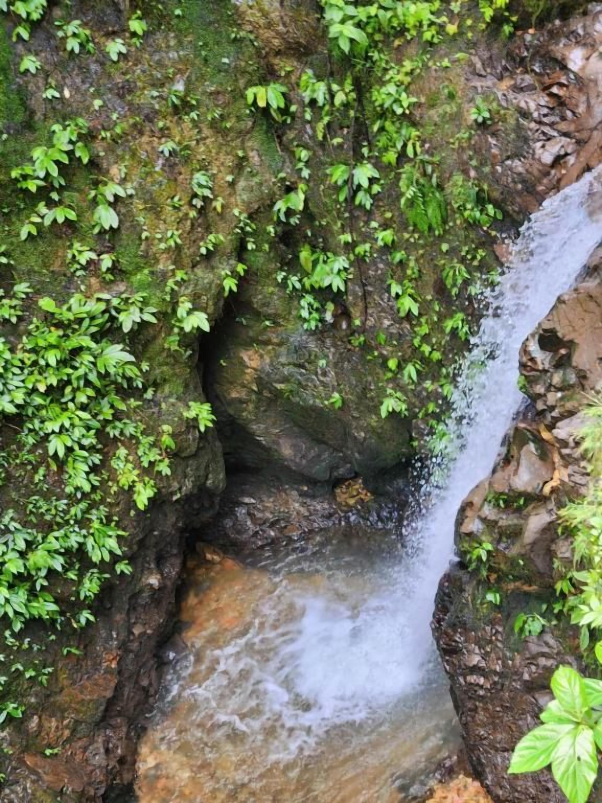 A natural rock formation with a small waterfall.