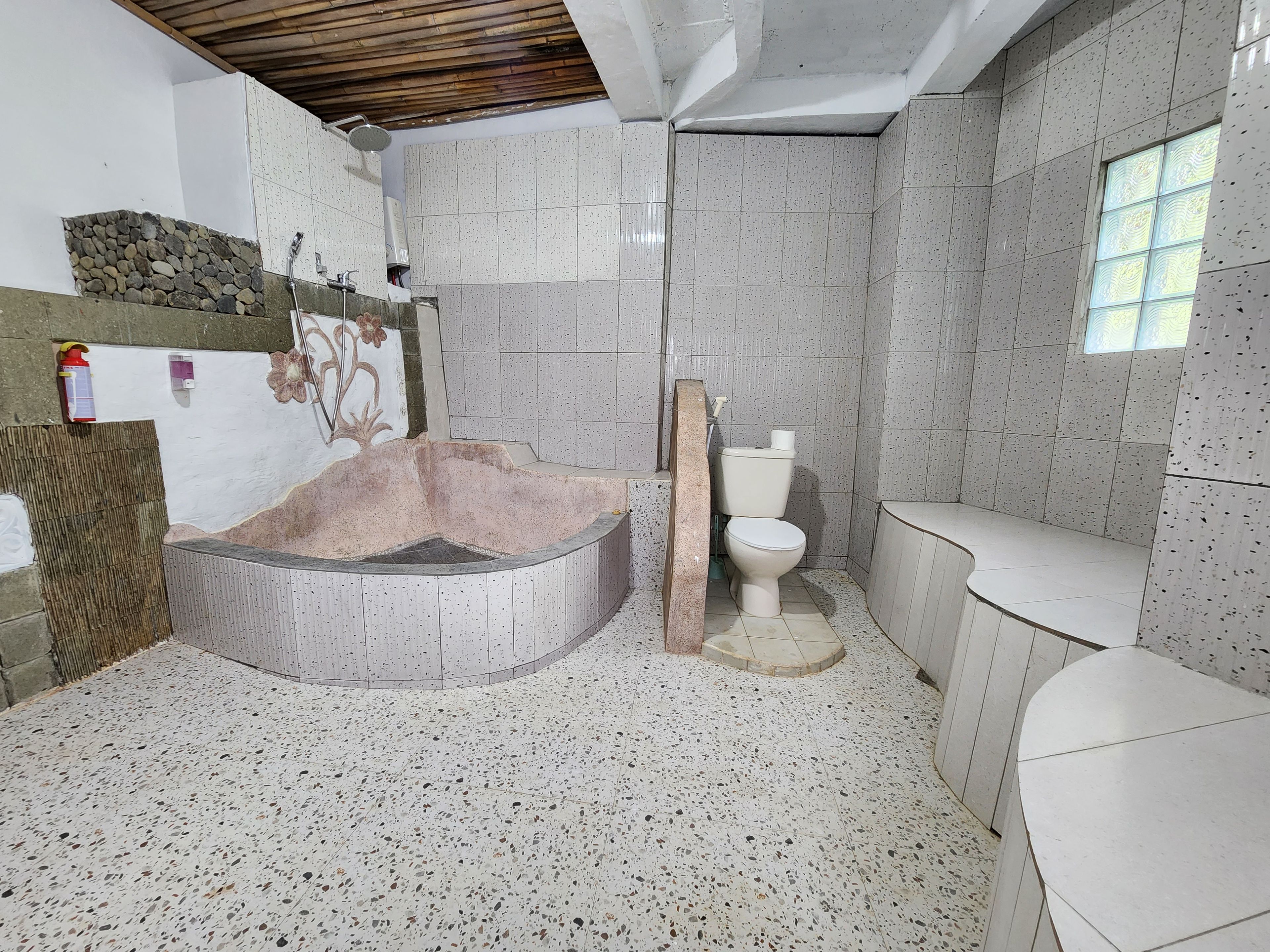 A bathroom with a freestanding bathtub, a toilet, and a sink.