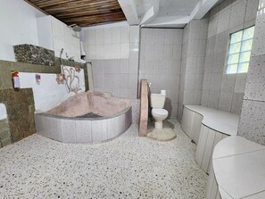 A bathroom with a freestanding bathtub, a toilet, and a sink.