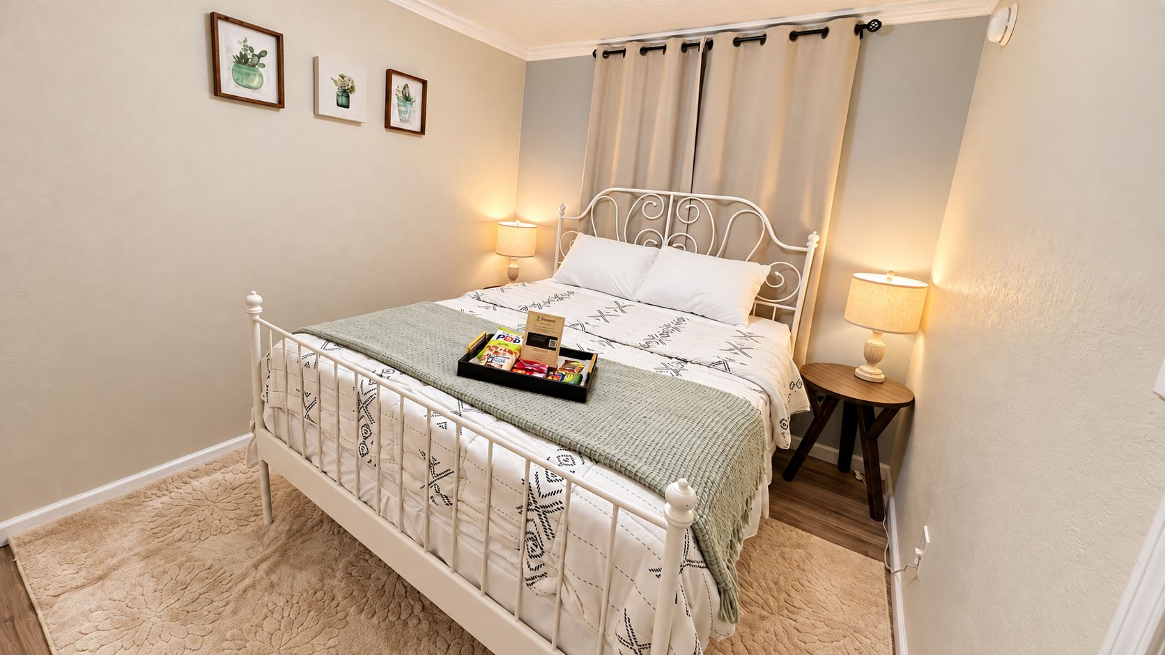 A bedroom with a bed, bedside lamps, a bedside table, and a small rug.