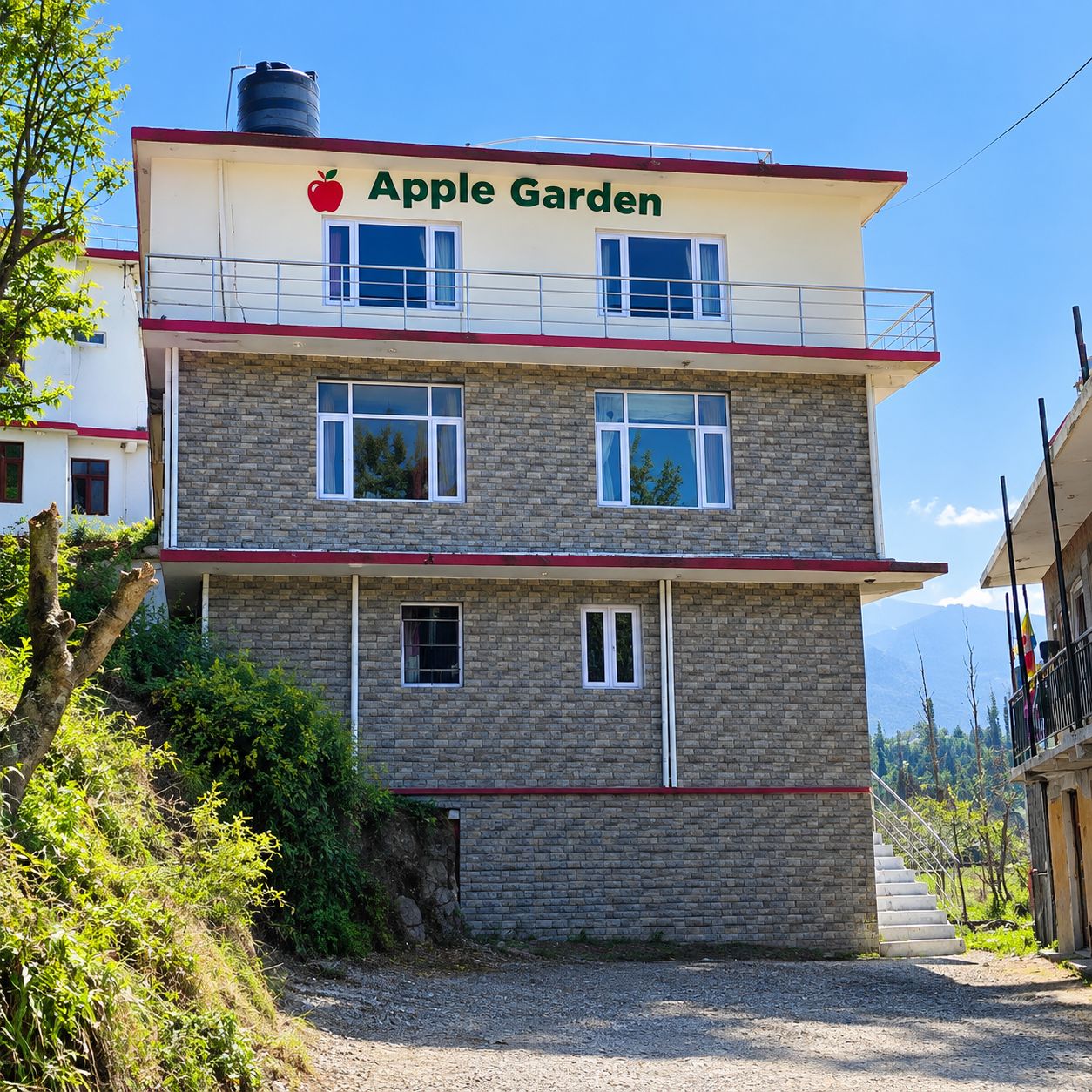 A two-story building with a sign reading 'Apple Garden' and a red apple logo.