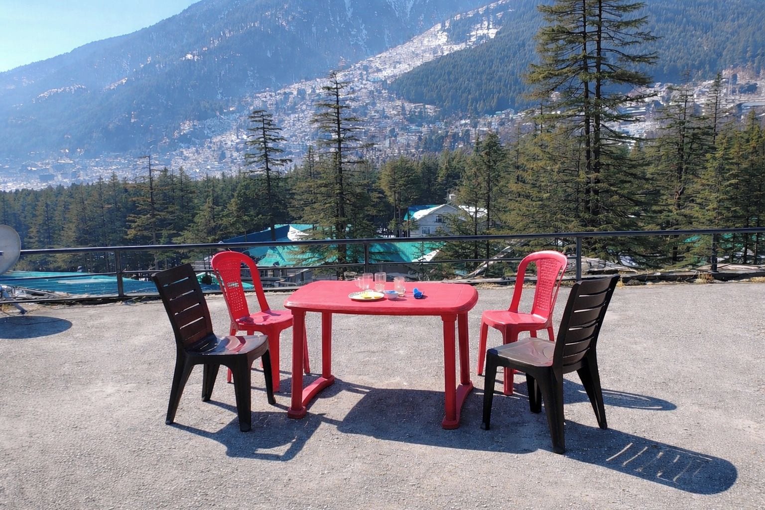 A table and chairs set outdoors with a mountain view in the background.