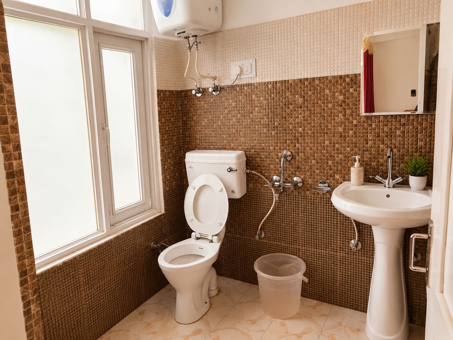 A bathroom with a toilet, bidet, sink, and a window.