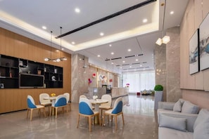 Un lobby moderno de hotel con una recepción, zona de estar y un ventanal grande.