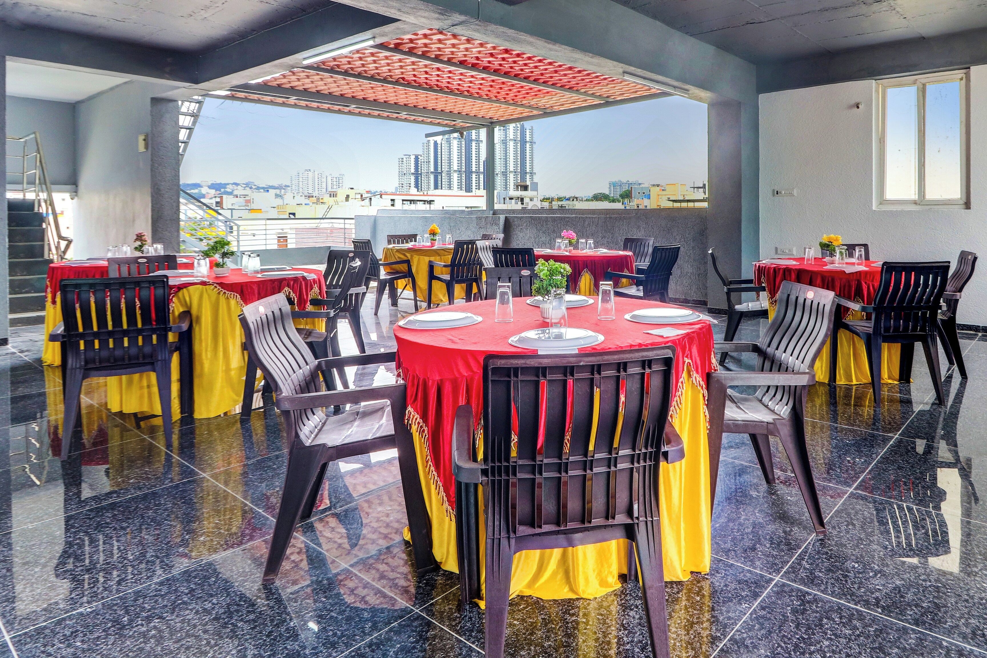 Ein Dachrestaurant mit gedeckten Tischen, Stühlen und Blick auf die Stadtlandschaft.