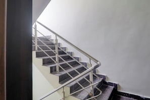 Una escala amb baranes metàl·liques i graons foscos, que puja.