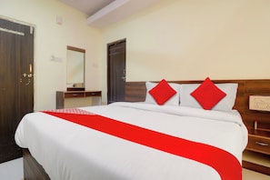 A hotel room with a large bed, a wooden headboard, a bedside table, and a mirror. - HOTEL O SHAZEB INTERNATIONAL (Hyderabad)