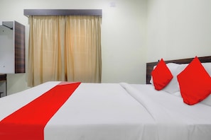 A hotel room with a bed, a nightstand, a lamp, a window with curtains, and a wall-mounted light switch. - HOTEL O SHAZEB INTERNATIONAL (Hyderabad)