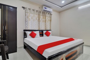 A hotel room with a bed, a wardrobe, a curtain, and an air conditioning unit. - Hotel O Shri Ganesh Residency (Hyderabad)