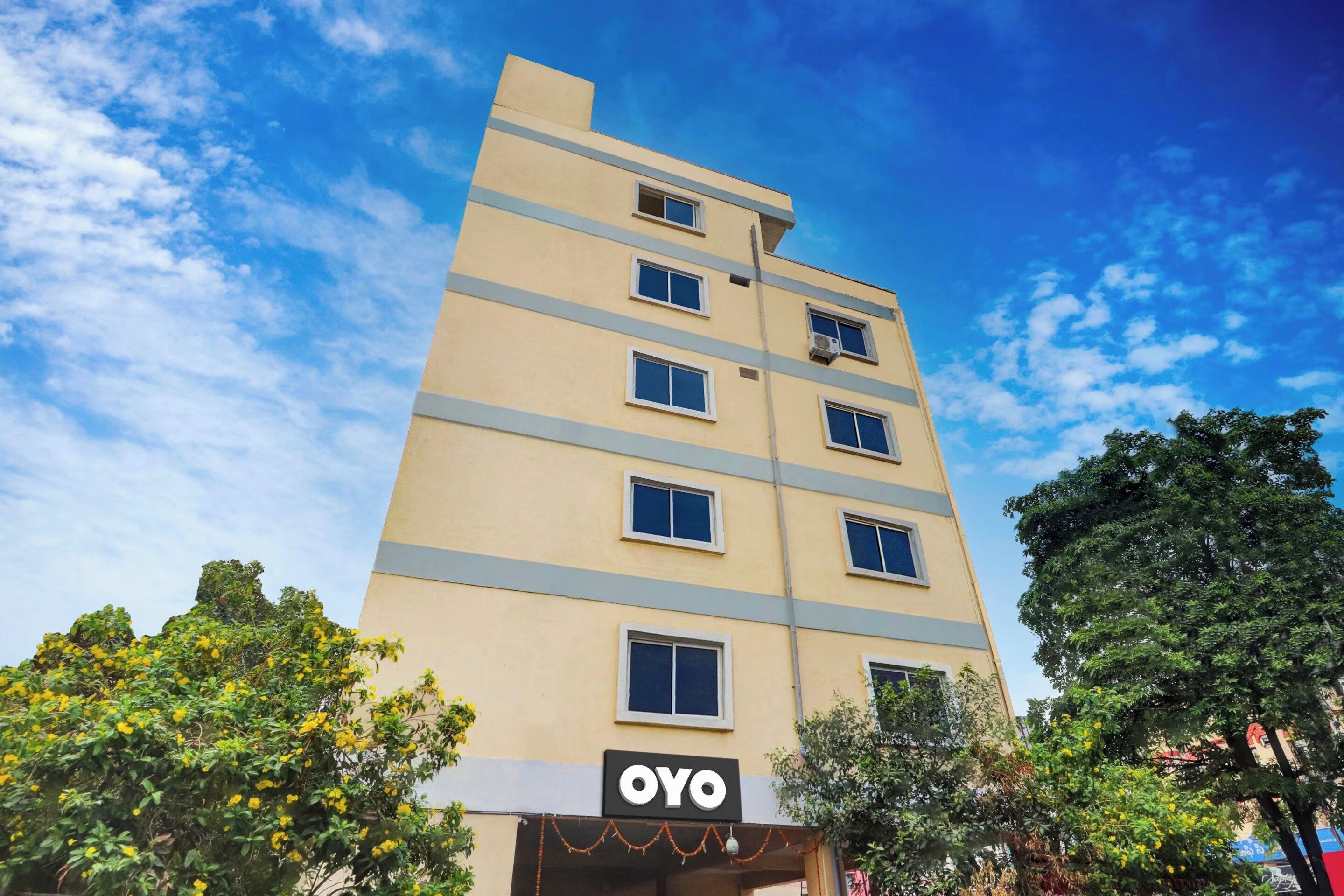 En byggnad med flera våningar, och på bottenvåningen finns en skylt med texten ”OYO”.