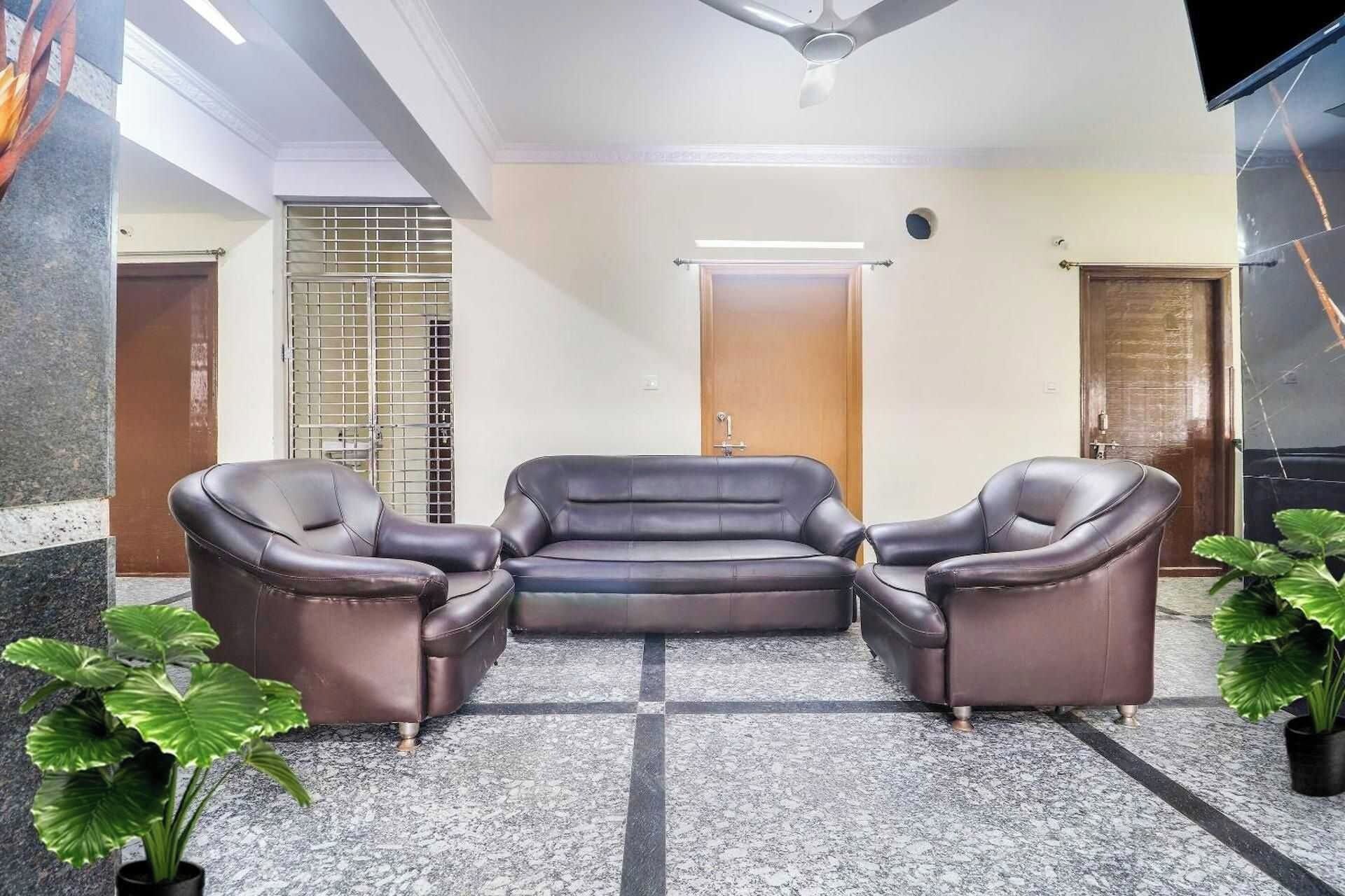 A lobby with a seating area, a ceiling fan, and a door in the background.