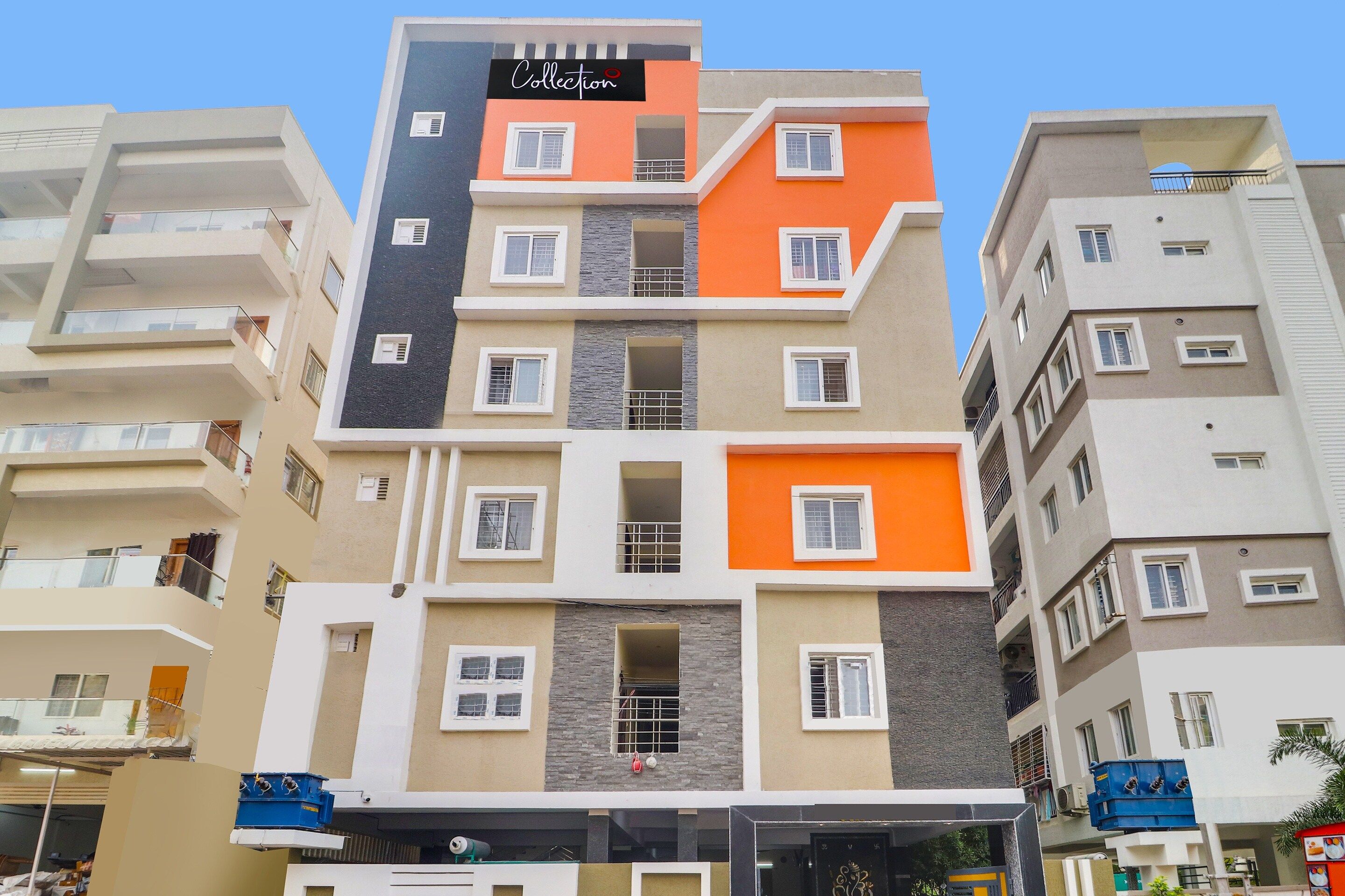 A multi-story residential building with balconies, a sign reading 'Collection', and a mix of window styles.
