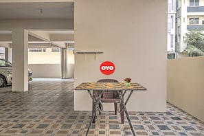A table with a logo, a chair, and a vase with flowers. - Hotel O by OYO Walk Inn Hotels (Hyderabad)