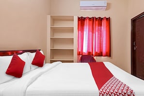 A hotel room with a bed, a desk, a chair, a wardrobe, and a window with curtains. - Hotel O by OYO Walk Inn Hotels (Hyderabad)