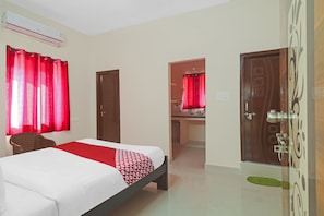 A hotel room with a bed, a chair, a desk, and a bathroom visible through an open door. - Hotel O by OYO Walk Inn Hotels (Hyderabad)