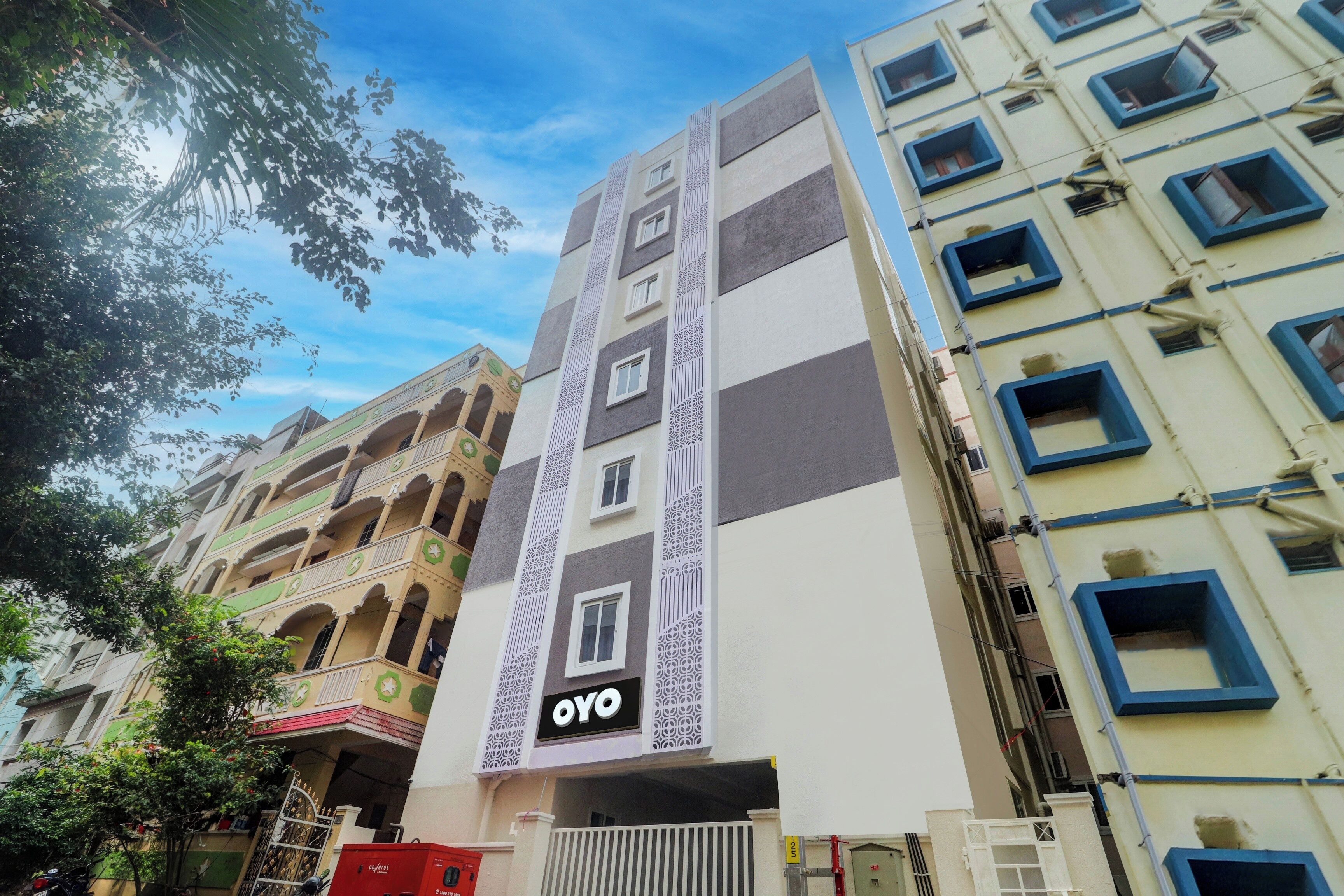 A multi-story building with a prominent 'OYO' sign on the facade, indicating a hotel or lodging establishment.