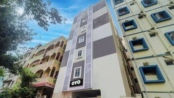 A multi-story building with a prominent 'OYO' sign on the facade, indicating a hotel or lodging establishment.