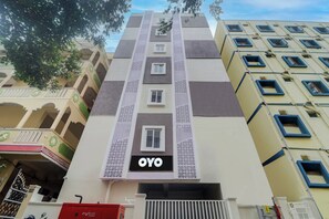 Un edificio de varios pisos con un letrero llamativo que dice 'OYO' en la fachada.