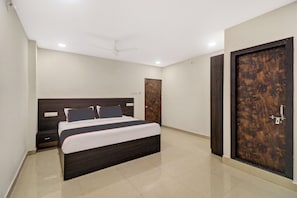 Ein Schlafzimmer mit Bett, Kleiderschrank, Nachttisch und Deckenventilator.
