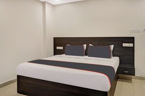 A modern bedroom with a large bed, two bedside tables, and a dark wood headboard. - Super Collection O Pnr International (Hyderabad)