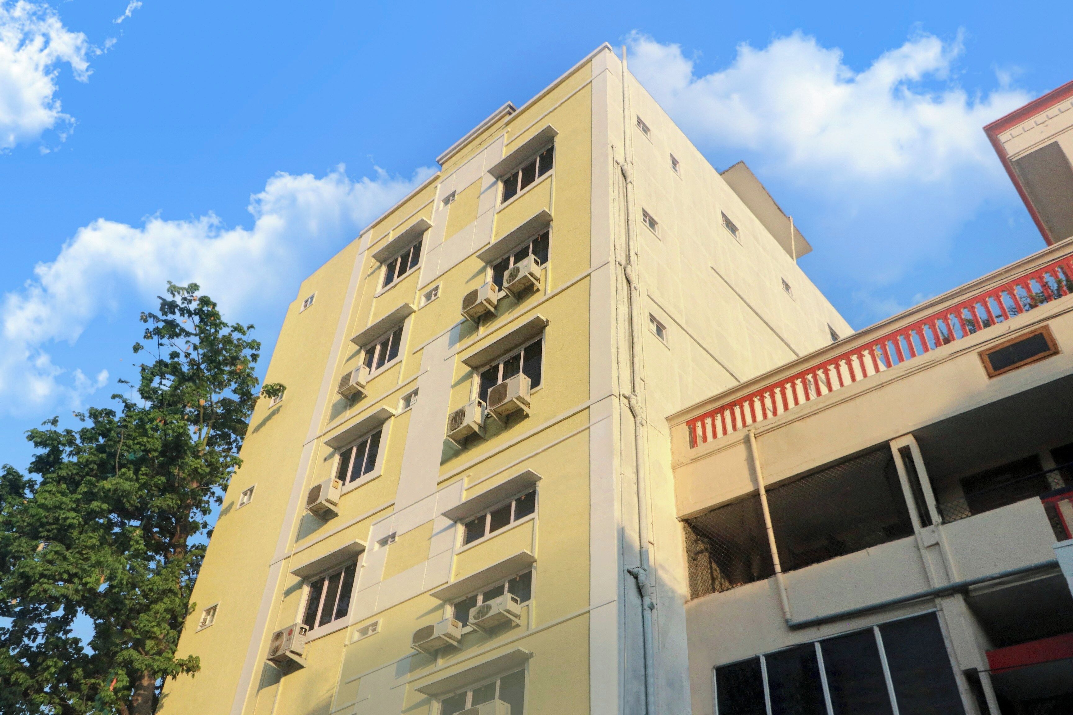 Un edificio de varios pisos con balcones y unidades de aire acondicionado.