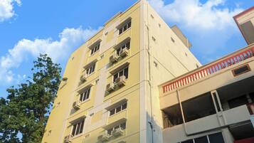 Un edificio de varios pisos con balcones y unidades de aire acondicionado.