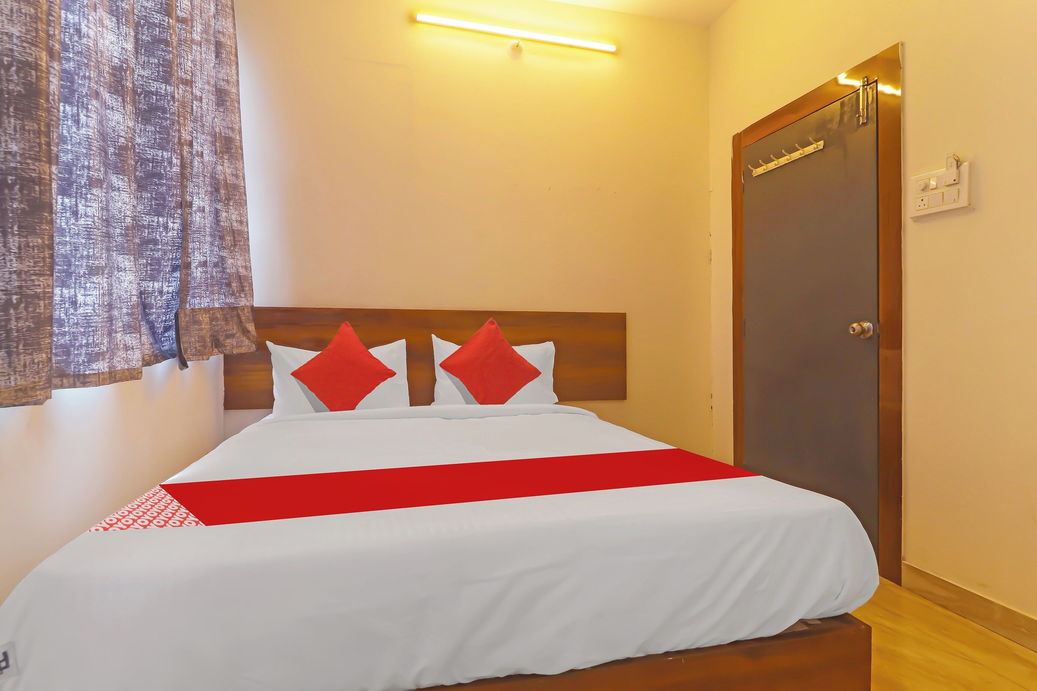 Una habitación de hotel con una cama, una puerta y una lámpara.
