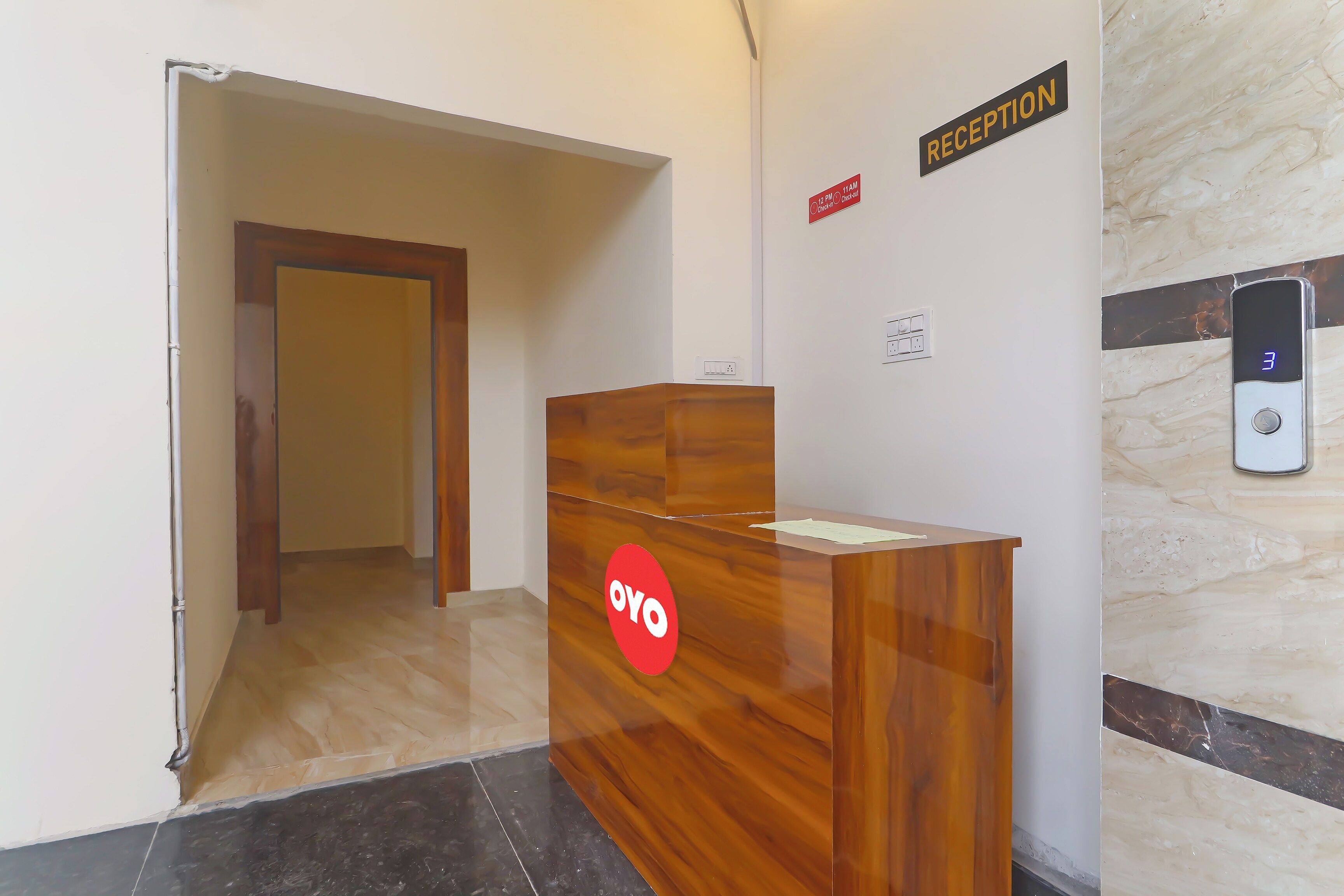 Una mesa de recepción con un letrero que dice 'Reception', un letrero que dice 'Check-in' y una pantalla digital que muestra el número '3'.