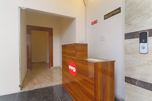 A reception desk with a 'Reception' sign, a 'Check-in' sign, and a digital display showing the number '3'. - Hotel O Ragas Inn (Hyderabad)