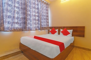 A bed with a wooden headboard, white bedding, and red accents. - Hotel O Ragas Inn (Hyderabad)
