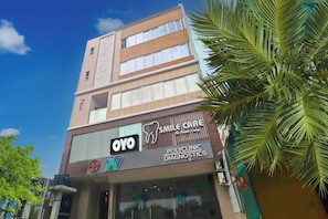 A multi-story building with signage for a dental clinic and a pharmacy. - Hotel O Ragas Inn (Hyderabad)