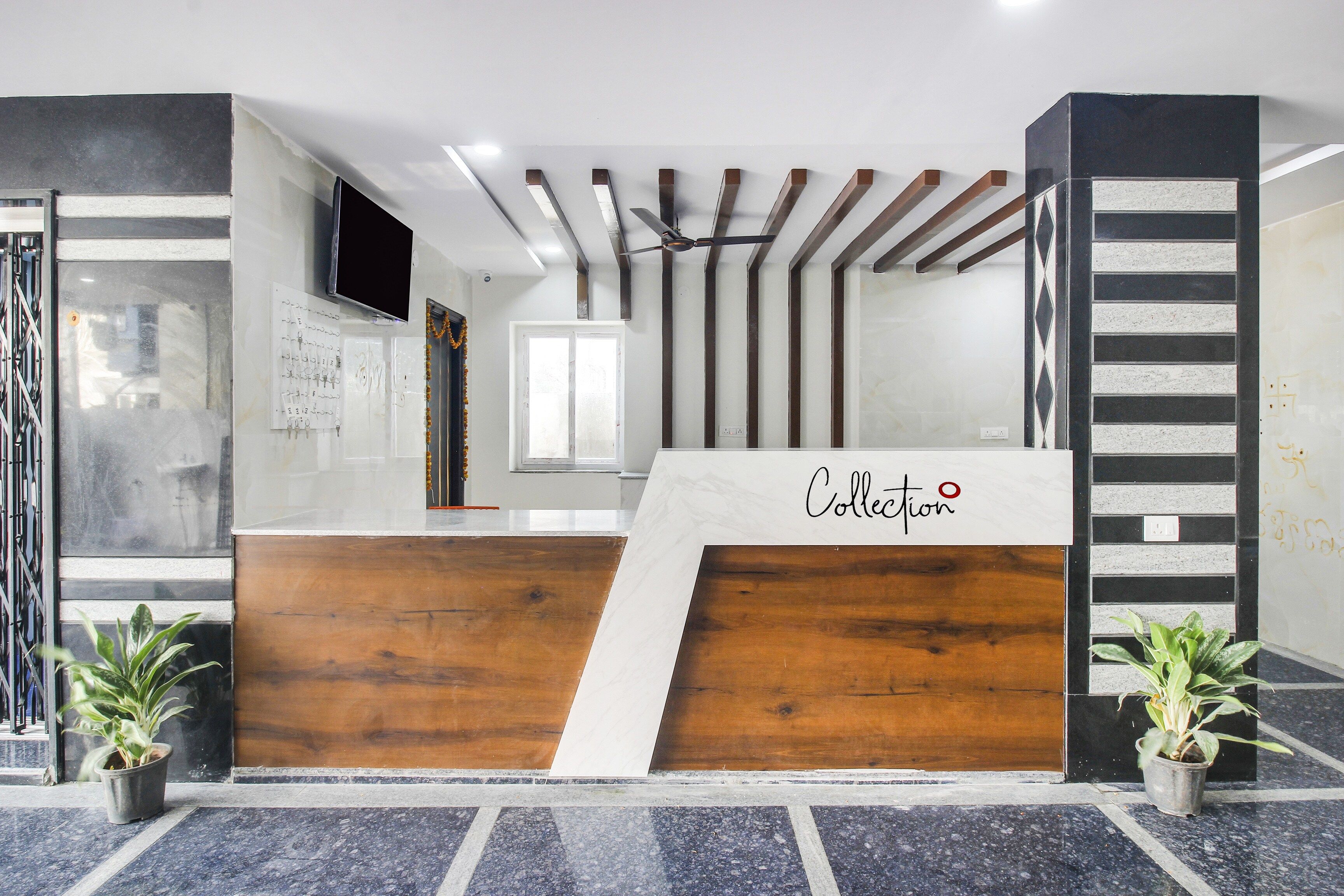 Un comptoir d’accueil avec un revêtement en bois et une enseigne indiquant « Collection ».