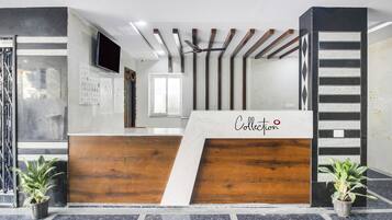 Un comptoir d’accueil avec un revêtement en bois et une enseigne indiquant « Collection ».